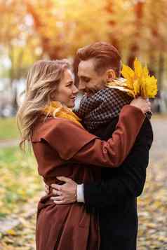 半身的肖像接吻年轻的夫妇丈夫妻子拥抱微笑秋天公园户外拍摄年轻的夫妇爱秋天公园