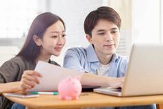 年轻的夫妇规划预算移动PC屏幕检查财务状况