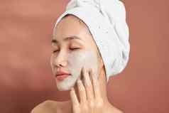 水疗中心女人应用面部粘土面具美治疗