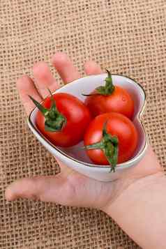 红色的樱桃Tomatos心形状的碗