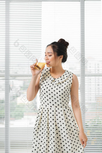 年轻的有吸引力的亚洲女人喝热<strong>茶首页</strong>