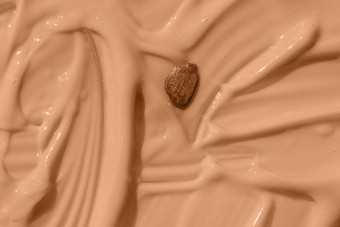 摘要化妆品变形背景指甲波兰的下降米色液体基金会纹理保湿美噪音乳香斯沃琪粉红色的油漆酸奶纹理