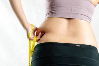 脂肪女人脂肪肚子胖乎乎的肥胖女人手捏<strong>过度</strong>肚子脂肪腰测量磁带女人饮食生活方式概念后视图