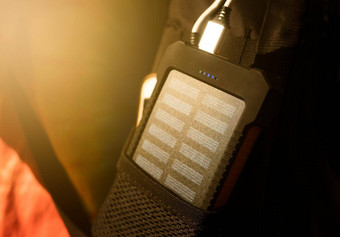 可充电移动权力包太阳能面板年轻的女旅行者的背包特写镜头连接充电移动平板电脑聪明的电话