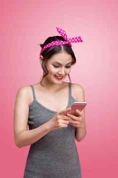 美丽的年轻的亚洲女人美女化妆发型粉红色的背景移动电话