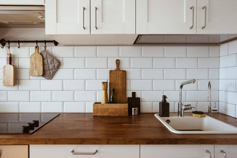 厨房黄铜餐具老板配件挂厨房白色瓷砖墙木桌面厨房背景