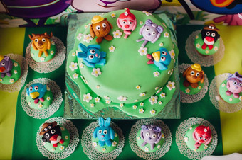 节日孩子们的表格美丽的蛋糕装饰绿色多色的饼干糖果孩子们的生日蛋糕孩子们的生日卡通风格