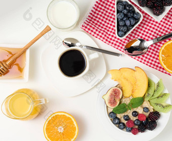 杯黑色的咖啡板燕<strong>麦片水果</strong>蜂蜜玻璃牛奶白色表格健康的早....早餐前视图
