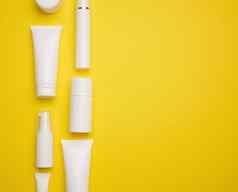 Jar瓶空白色塑料管化妆品黄色的背景包装奶油过来这里血清广告产品促销活动模拟