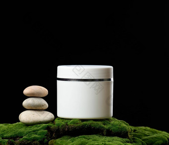 轮白色塑料Jar成员化妆品站绿色莫斯黑色的背景自然面霜面具产品品牌