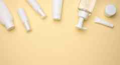 前视图白色奶油管化妆品自动售货机空罐子手奶油透明的自动售货机光黄色的背景品牌化妆品产品模拟