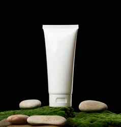 空白色塑料管化妆品站绿色莫斯黑色的背景包装奶油过来这里血清广告产品促销活动模拟