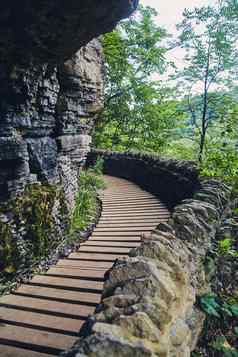 美丽的木木板路石头墙岩石悬崖覆盖莫斯