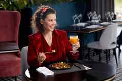 优雅的年轻的女人吃虾沙拉午餐奢侈品餐厅健康的生活方式饮食概念