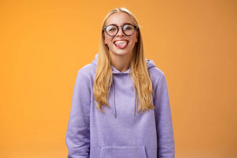 有趣的迷人的女程序员有趣的显示舌头傻瓜同事午餐打破微笑广泛的笑可爱的眼镜紫色的连帽衫站紫色的背景
