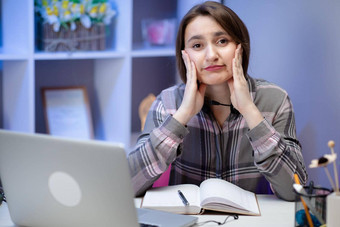 可爱的女孩不知所措坐着桌子上首页家庭作业压力情绪惊讶富有表现力的研究学习首页