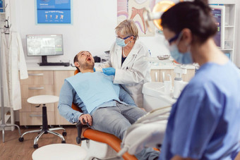 生病的病人坐着牙科椅子开放口