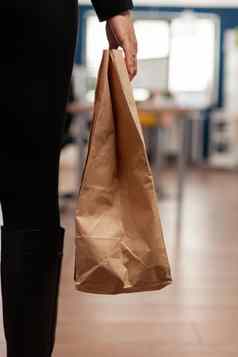 女商人持有交付外卖食物餐订单纸袋外卖午餐时间