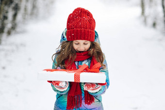 孩子持有礼物盒子惊喜脸孩子红色的他圣诞节礼物盒子雪冬天户外有趣的孩子玩雪公园