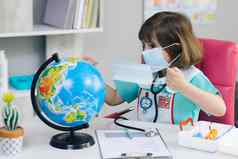 可爱的孩子女孩医生把面具全球地球地球保存地球地球手未来手女孩穿着医生的西装对待地球地球