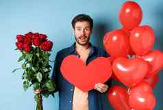 男人。爱带惊喜礼物浪漫的日期持有花束红色的玫瑰情人节红色的心站气球情人蓝色的背景