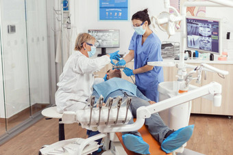 牙医医生医疗护士使专业牙齿清洁生病的男人。