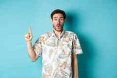 惊讶高加索人旅游夏威夷衬衫指出手指哇检查促销活动站蓝色的背景