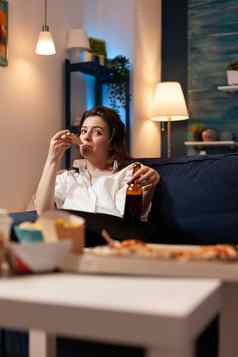 高加索人女放松沙发吃披萨片喝啤酒娱乐电影