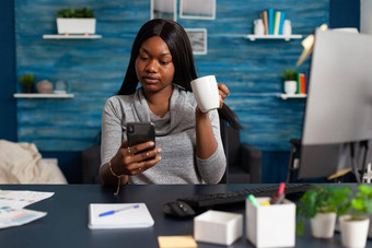 非洲美国女人持有杯咖啡手社交活动朋友智能手机