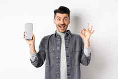 兴奋微笑的家伙显示空智能手机屏幕手势推荐应用程序购物提供站白色背景