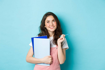 美丽的女孩学生深思熟虑的前复制空间站笔记本电脑家庭作业微笑沉思的站蓝色的<strong>背景</strong>