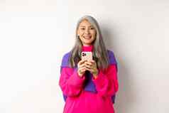 快乐亚洲女人微笑相机阅读促销活动智能手机站移动电话白色背景
