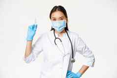 亚洲护士医疗面具持有注射器疫苗概念医疗保健疫苗接种站诊所统一的白色背景