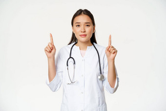 微笑亚洲女医生指出手指相机提供医疗医疗保健信息白色背景