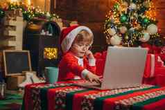 礼物服务聪明的蹒跚学步的冲浪互联网助手圣诞老人圣诞节魔法礼物圣诞节首页圣诞节时间男孩圣诞老人他服装有趣的