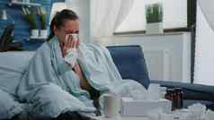 生病的女人组织打击流鼻涕的鼻子冷