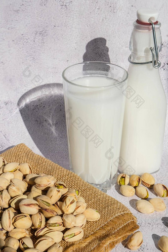 玻璃健康的阿月浑子牛奶站混凝土背景饮食牛奶素食者食物谷蛋白免费的特写镜头阿月浑子乳糖免费的牛奶饮食营养替代食物素食主义