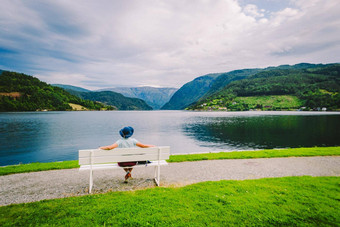 女人坐着板凳上峡湾于尔维克的<strong>酒店</strong>挪威峡湾沿海散步于尔维克的<strong>酒店</strong>Hordaland县挪威孤独的旅游他坐在回来板凳上欣赏风景斯堪的那维亚
