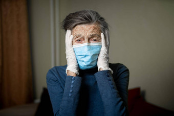伤心高级女人保护面具乳胶手套首页冠状病毒流感大流行保持首页奶奶退休隔离疫情科维德灰色的头发女面具感染细菌流感