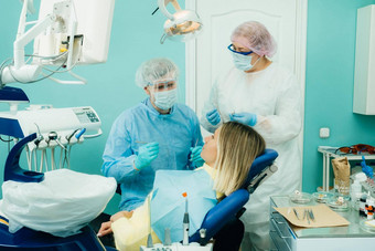 牙医保护面具坐在对待病人牙科办公室助理