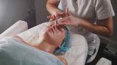 女人医生并以化妆品过程面具面部按摩水疗中心沙龙护肤品