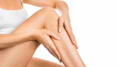 女人应用保湿霜完美的腿孤立的白色背景皮肤身体护理概念