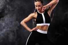 强大的运动女人黑色的背景穿黑色的时尚运动服装健身体育运动动机体育运动概念复制空间