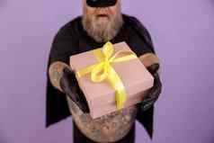 男人。超重狂欢节服装紫色的背景焦点手礼物盒子