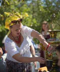 8月克拉斯诺维多沃俄罗斯成熟的女人倒茶茶壶