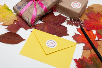 感恩节背景黄色的信封登记礼物美丽的丝带枫木秋天叶子白色表格复制空间平躺前视图感恩节假期