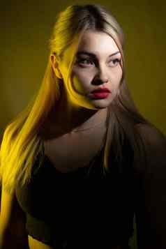 肖像金发女郎女孩明亮的化妆黄色的光