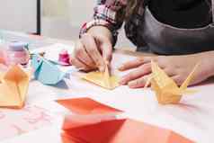 关闭女人手使有创意的艺术工艺折纸纸