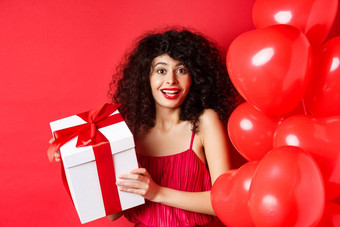 假期庆祝活动美丽的女人卷曲的头发站心气球持有礼物盒子微笑快乐白色背景