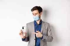 科维德流感大流行业务概念办公室工人医疗面具指出瓶手洗手液防腐剂工作白色背景